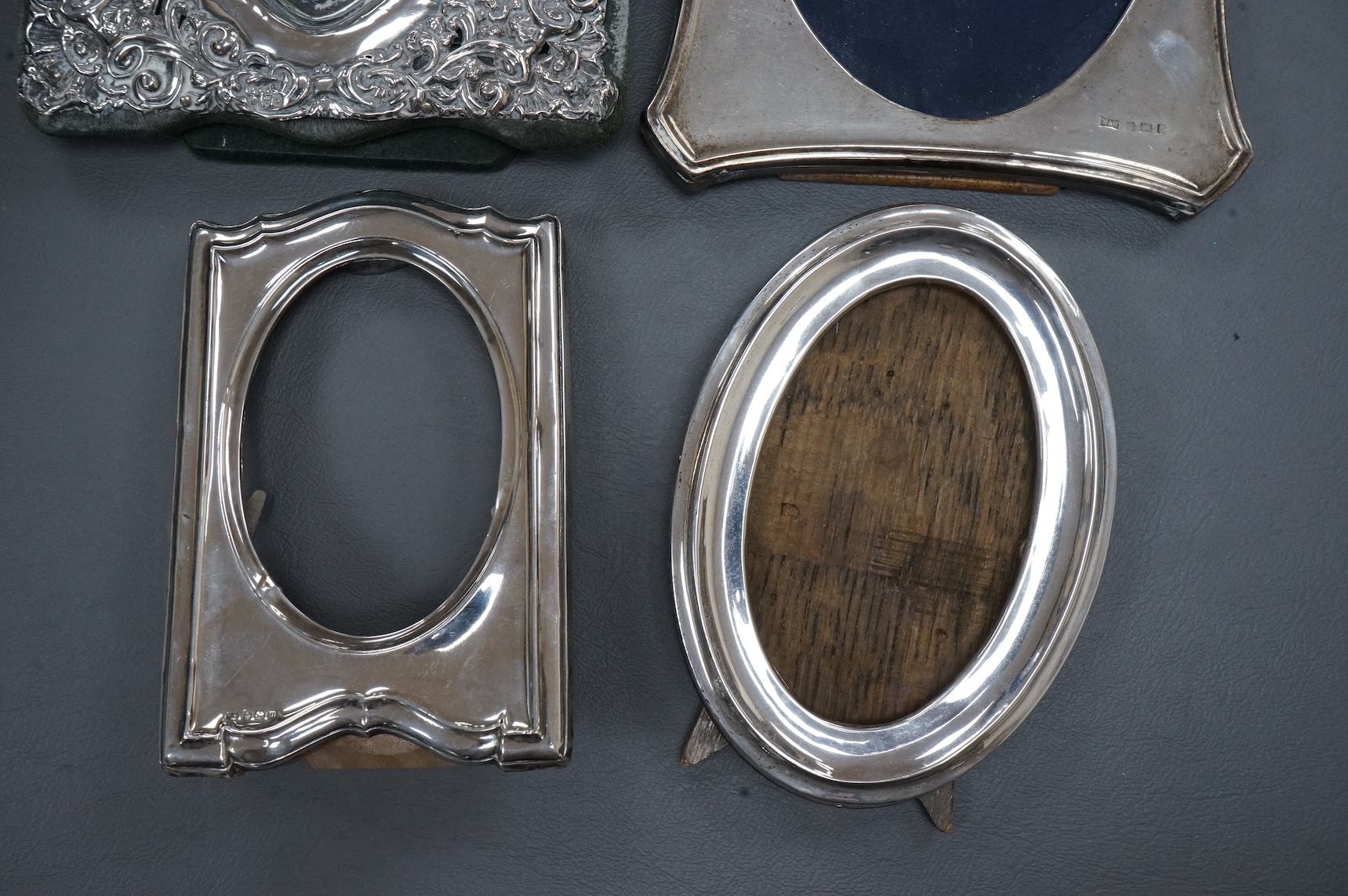 Four assorted early 20th century silver mounted photograph frames, the largest with pierced decoration, Chester, 1902, 19.5cm.